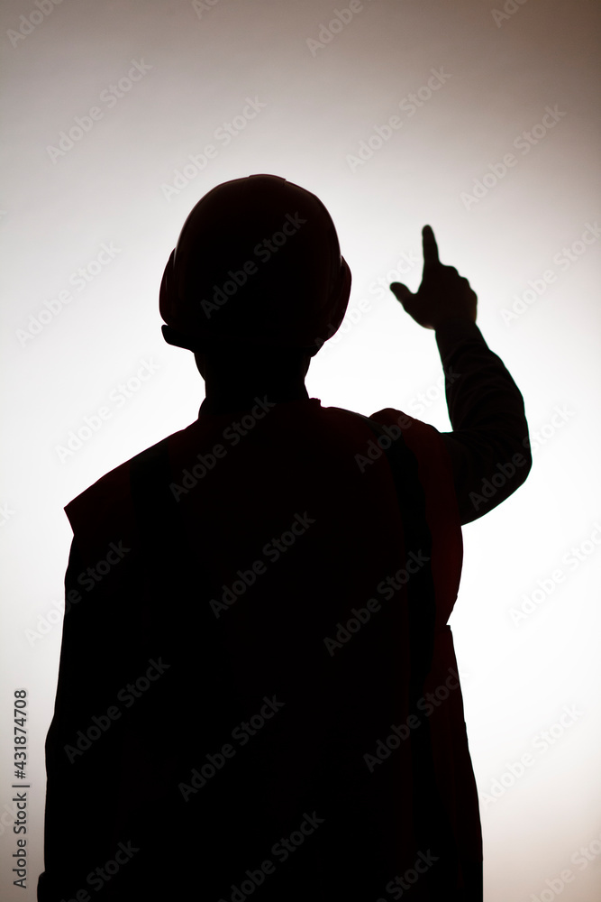 silhouette back of young construction worker in hard hat on isolated background showing with hand direction forward, goal concept,foreman controls work