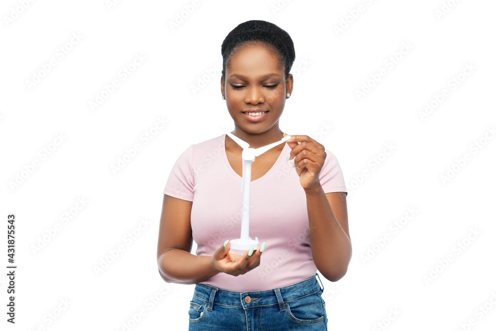 sustainable energy, power and people concept - happy smiling young african american woman with toy wind turbine over white background sustainable energy, power and people concept - happy smiling young african american woman with toy wind turbine over white background