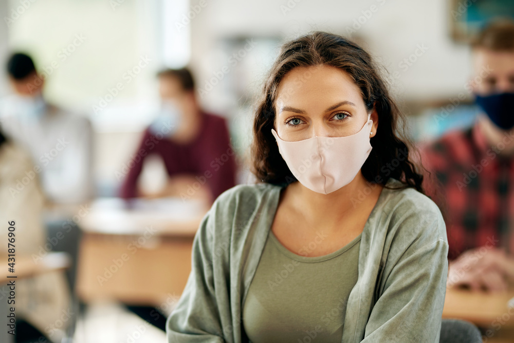 Portrait of female college student with protective face mask in the classroom.