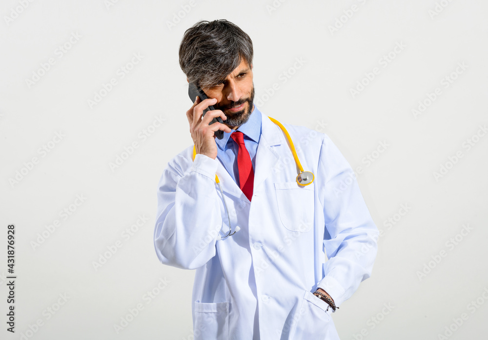 Handsome doctor using mobile phone on white Handsome doctor using mobile phone on white