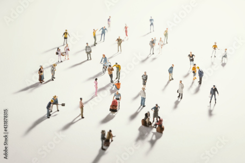 Top view of people (miniature toys) with long shadows keep distance away in public during sunrise or sunset.Social distancing during COVID-19 coronavirus outbreak spreading concept.