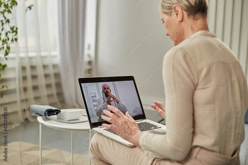 An elderly woman communicates remotely via a laptop with her doctor. Telemedicine concept An elderly woman communicates remotely via a laptop with her doctor. Telemedicine concept