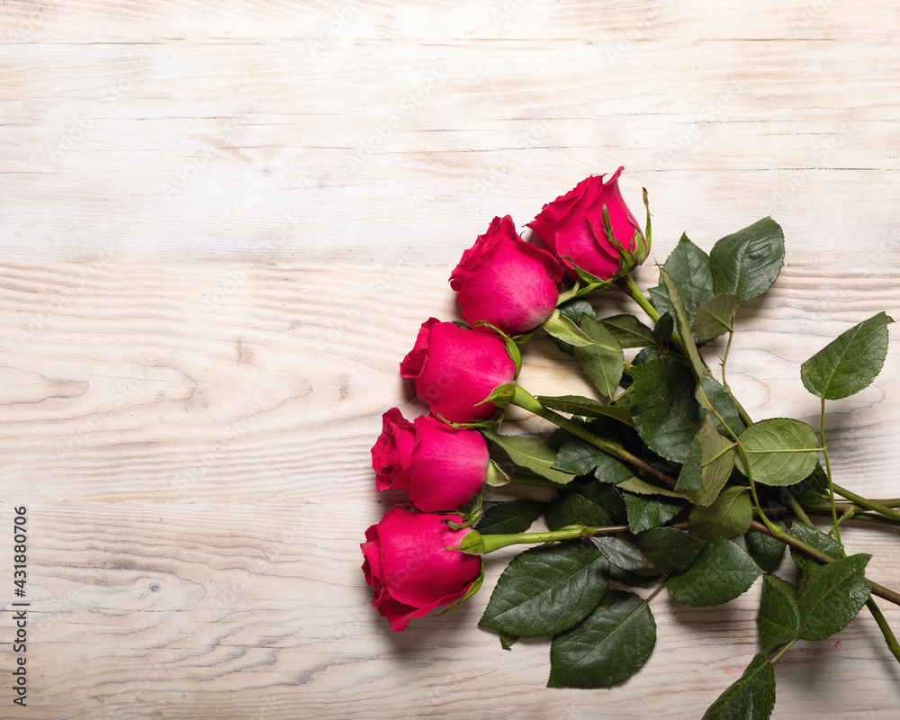 Bouquet of dark red roses on wood table background. Refinement of flowers. Pleasant and romantic gift for darling.