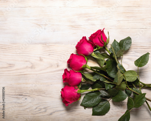 Bouquet of dark red roses on wood table background. Refinement of flowers. Pleasant and romantic gift for darling.