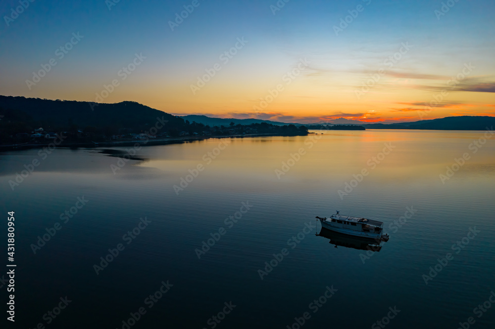 Sunrise waterscape with boats, light cloud and reflections