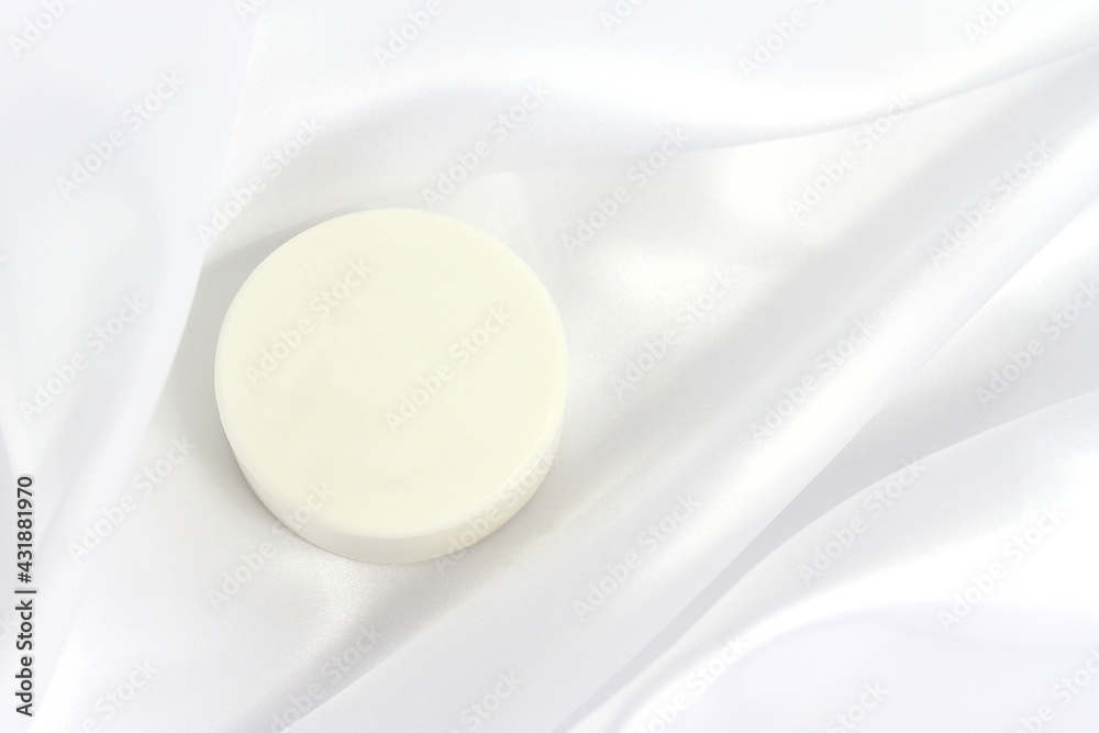 White solid soap shampoo bar on silk background, bath cosmetics White solid soap shampoo bar on silk background, bath cosmetics