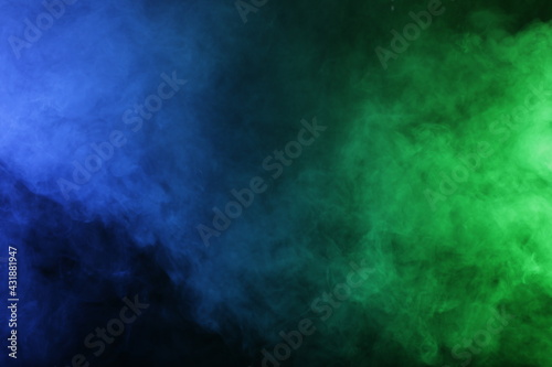Smoke in blue green light on black background © Qwenergy