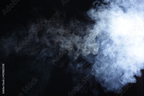 Illuminated smoke on black background in dark