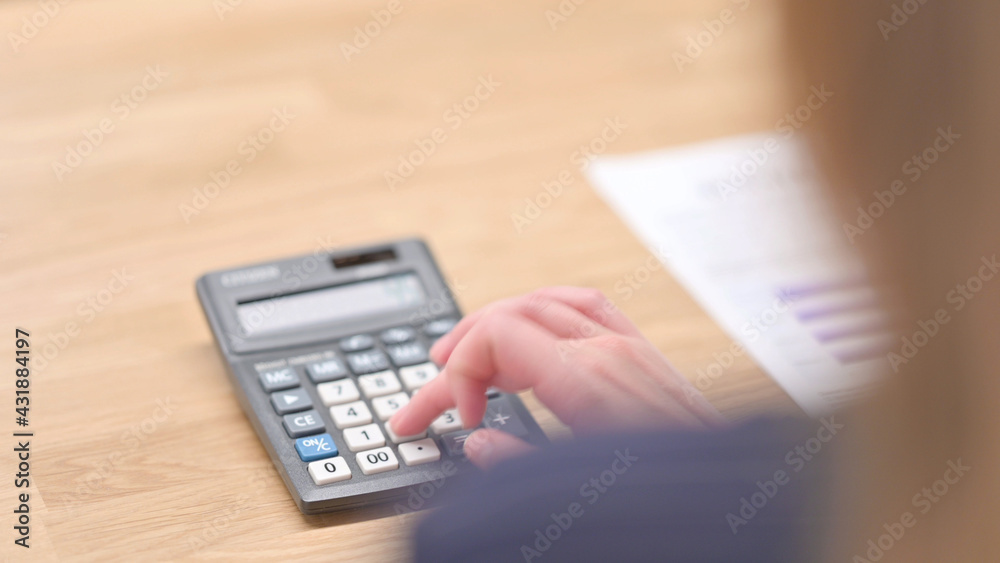 Rear View of Hands using Calculator in Close up Rear View of Hands using Calculator in Close up