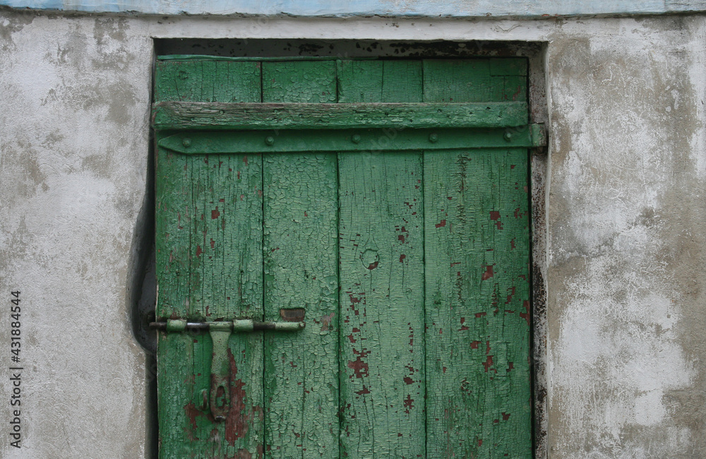 Old door with peeling green paint and a metal lock