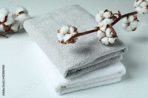 Cotton plant branches and towels on white background