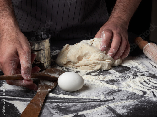 Photo of flour and men hands with flour splash. Cooking bread. Kneading the Dough.