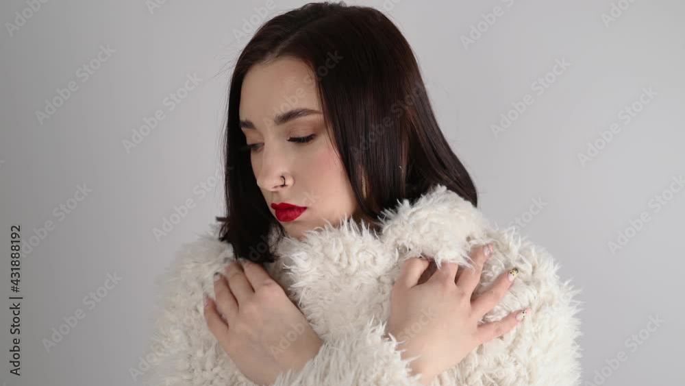 Young woman with great shapes brows, long eyelashes and red lips. Brunette posing on white wall Young woman with great shapes brows, long eyelashes and red lips. Brunette posing on white wall