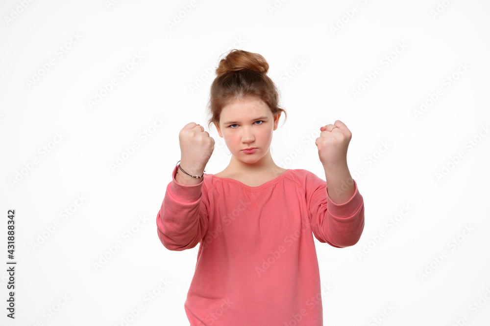 Severe little girl shaking fists and looking at camera. Human emotions, facial expression concept Severe little girl shaking fists and looking at camera. Human emotions, facial expression concept