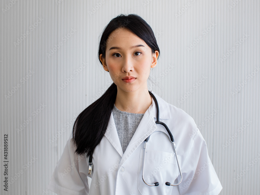 Asian woman doctor long black hair smiling look at camera wearing white uniform with stethoscope on her neck. Looks happy friendly and professional. Asian woman doctor long black hair smiling look at camera wearing white uniform with stethoscope on her neck. Looks happy friendly and professional.