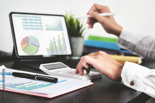 The young businessman using calculators and computers to check financial statements at home instead of working in the office