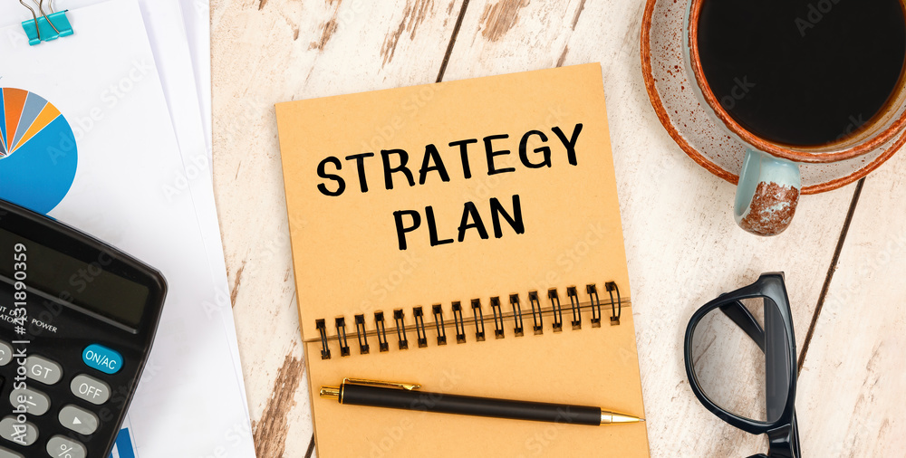 Naklejka premium Notebook with text STRATEGY PLAN near office supplies.