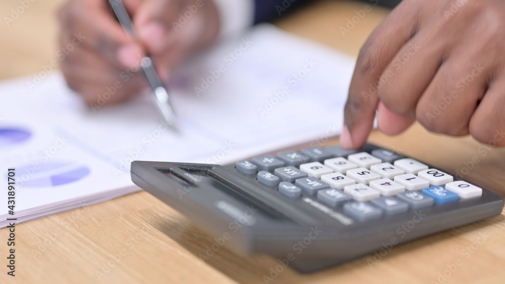 Close up of African Businessman Using Calculator Close up of African Businessman Using Calculator