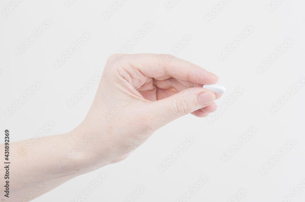 Doctor's appointment, Taking pills, hand with the one pill on a white background. Doctor's appointment, Taking pills, hand with the one pill on a white background.