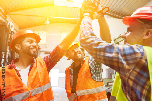 Workers in factory give high five for motivation photo