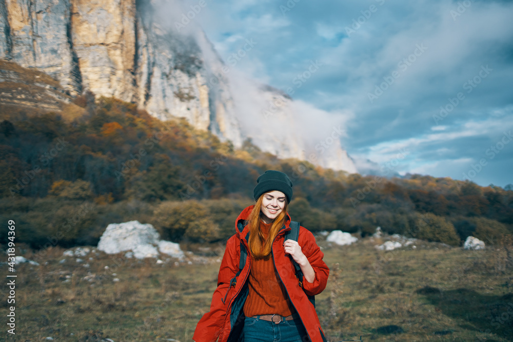 woman with backpack red jacket to travel blue sky high mountains rocks landscape