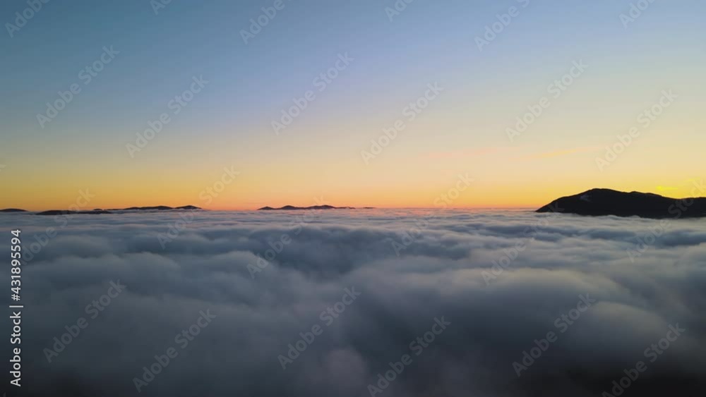 Aerial view of vibrant sunrise over mountain hills covered with evergreen spruce forest in autumn. Aerial view of vibrant sunrise over mountain hills covered with evergreen spruce forest in autumn.