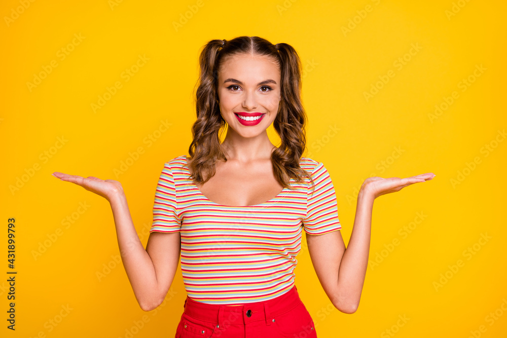 Photo of young attractive smiling cheerful girl hold hands in balance advertisement isolated on yellow color background Photo of young attractive smiling cheerful girl hold hands in balance advertisement isolated on yellow color background