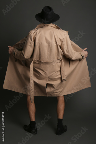 Εκτύπωση καμβά Exhibitionist exposing naked body under coat on black background, back view