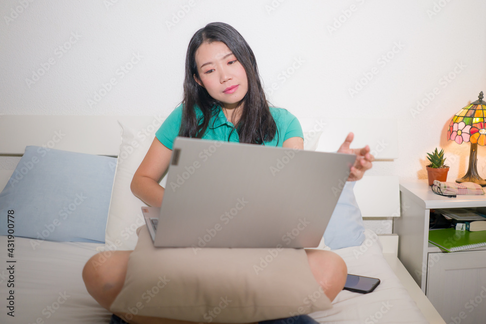 home lifestyle portrait of young happy and beautiful Asian Korean woman at home networking using laptop computer on bed smiling relaxed and cheerful home lifestyle portrait of young happy and beautiful Asian Korean woman at home networking using laptop computer on bed smiling relaxed and cheerful