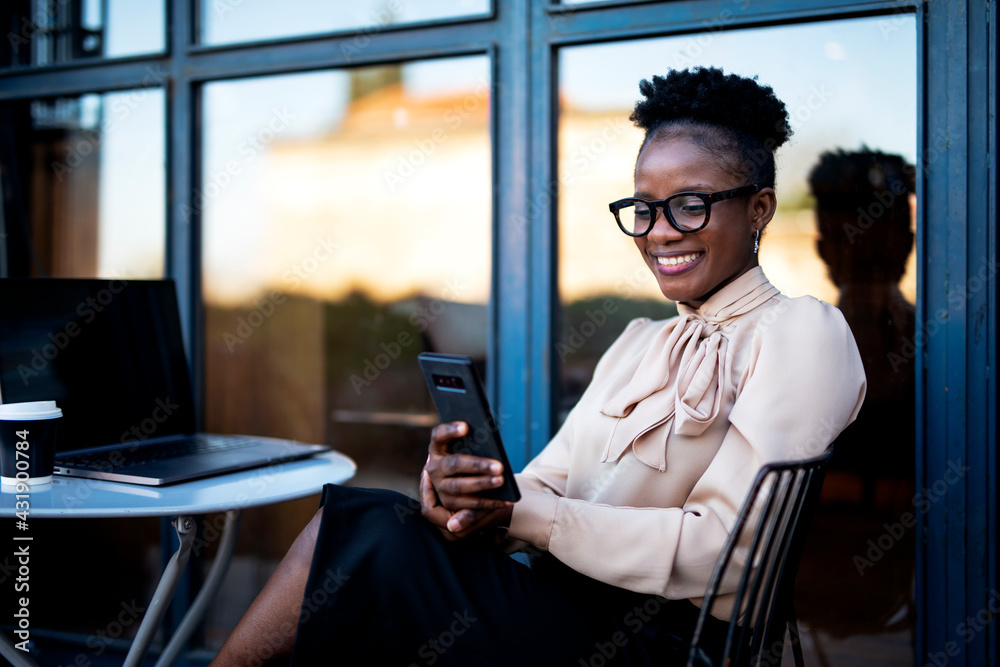 Businesswoman using the phone in cafe. African woman with laptop in coffee shop Businesswoman using the phone in cafe. African woman with laptop in coffee shop
