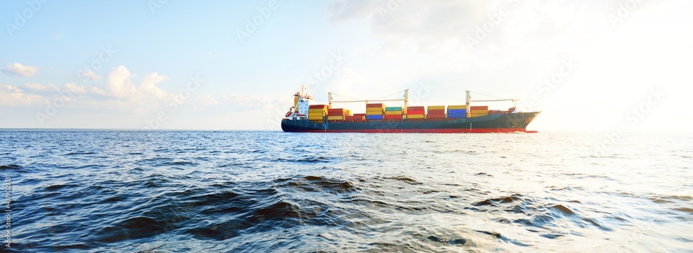 Large cargo container ship sailing from Europoort (Rotterdam, Netherlands) in an open sea on a clear day, close-up. Global communications, logistics, industry theme - obrazy, fototapety, plakaty 