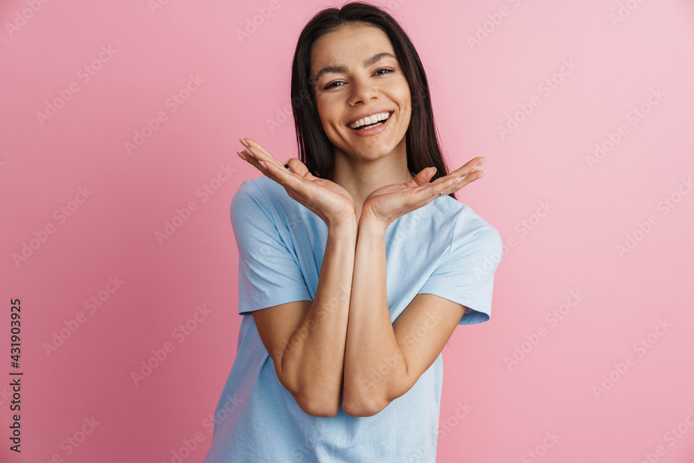 Excited hispanic woman holding copyspace and smiling at camera