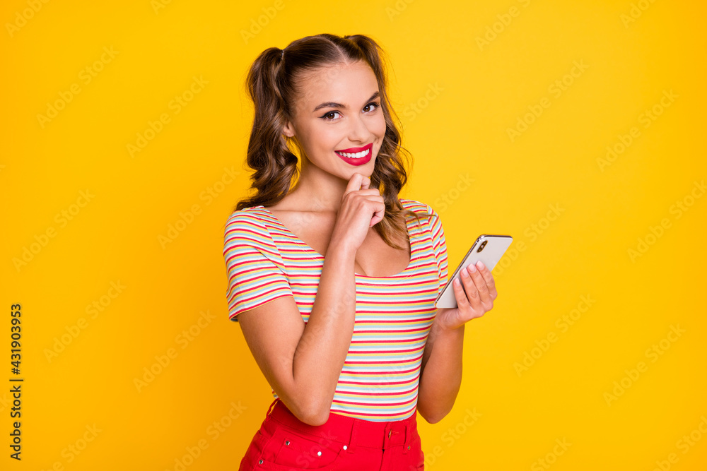 Photo of lovely lady hold telephone finger chin beaming smile wear striped shirt isolated yellow color background Photo of lovely lady hold telephone finger chin beaming smile wear striped shirt isolated yellow color background