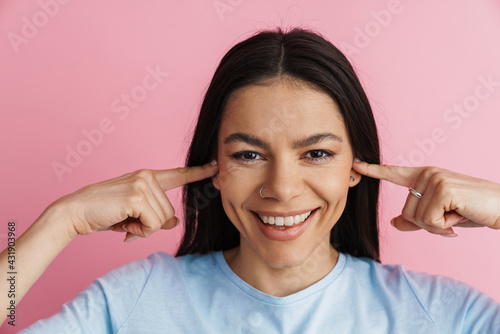 Fototapeta Naklejka Na Ścianę i Meble -  Young hispanic woman plugging her ears and smiling