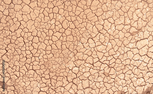 Mudflat cracked desert barren surface for natural background, layer, wallpaper, photo effect. Multicoloured drought effects of global warming