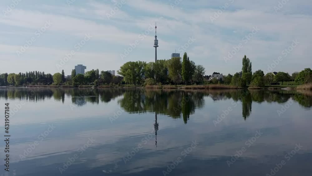 Drone with an ascending flight over the Old Danube River with a panoramic view of the Vienna International Center. The Old Danube River is a Recreational Area next to a business hub with skyscrapers. Drone with an ascending flight over the Old Danube River with a panoramic view of the Vienna International Center. The Old Danube River is a Recreational Area next to a business hub with skyscrapers.
