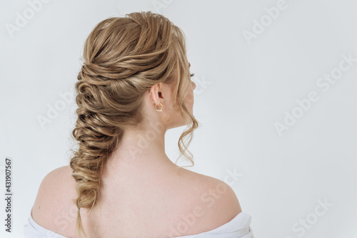 attractive blonde woman with a beautiful pigtail hairstyle on her hair on a white background copy space. the concept of hair care
