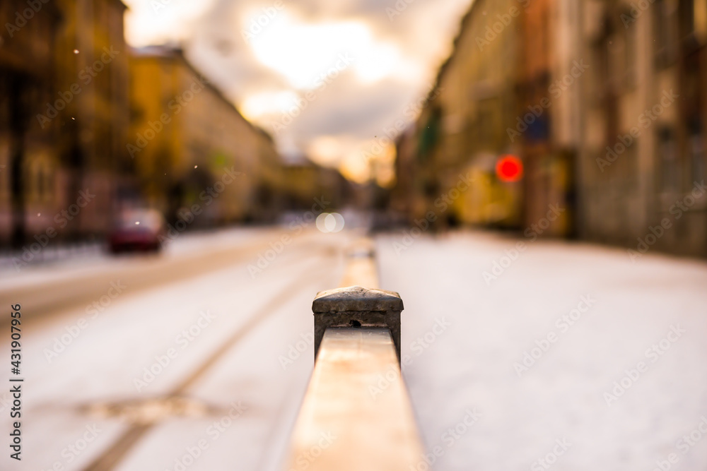 Bright winter sun in a big city, the empty road. Close up view from the handrail on the sidewalk level