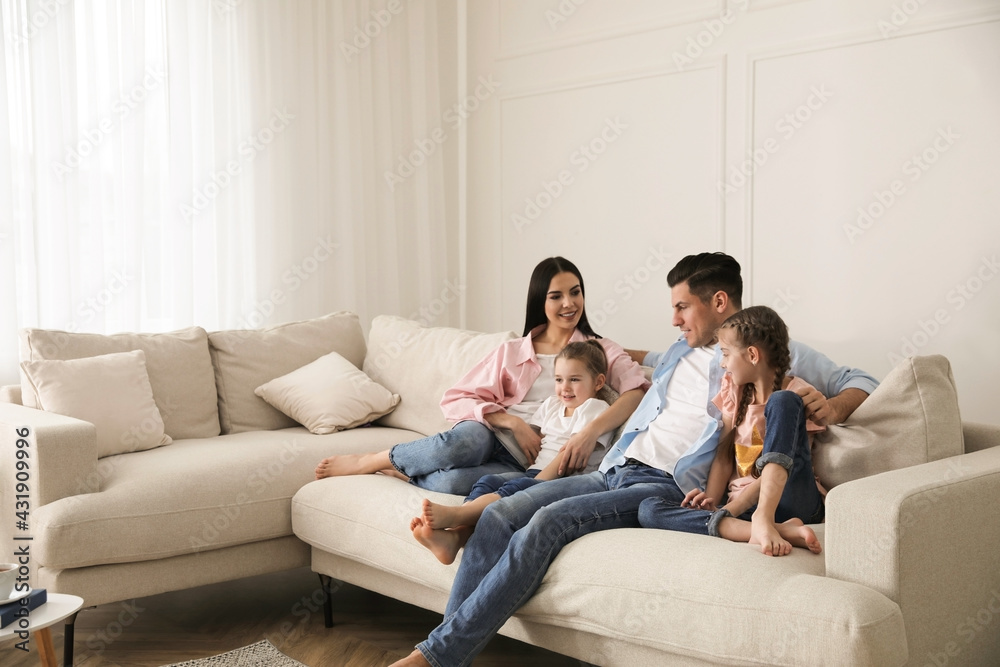 Happy family resting on comfortable sofa in living room