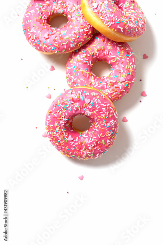 Amazing donuts isolated on white. Top view of yummy fresh homemade doughnuts. Light background for you text. Decorated with confetti in shape of little hearts.