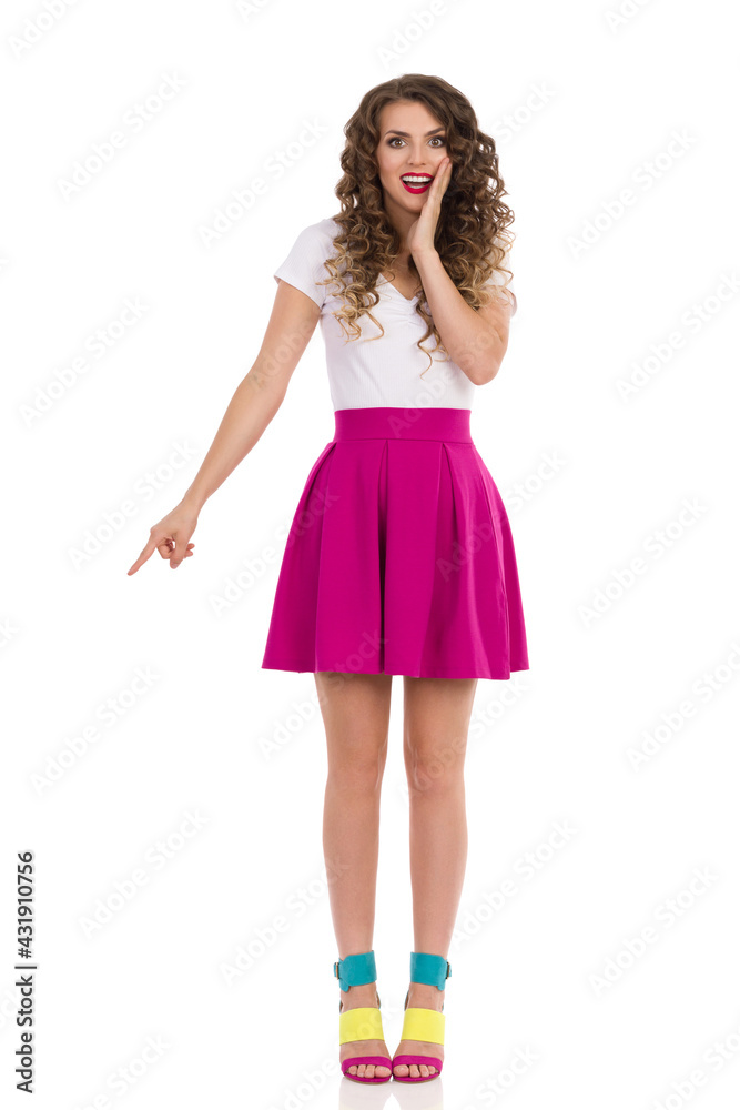 Excited Young Woman In Colorful High Heels Is Pointing Down.