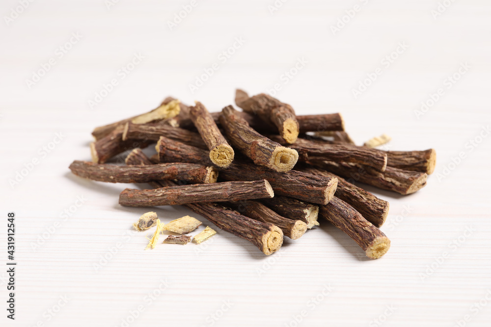 Fototapeta premium Dried sticks of liquorice root on white wooden table