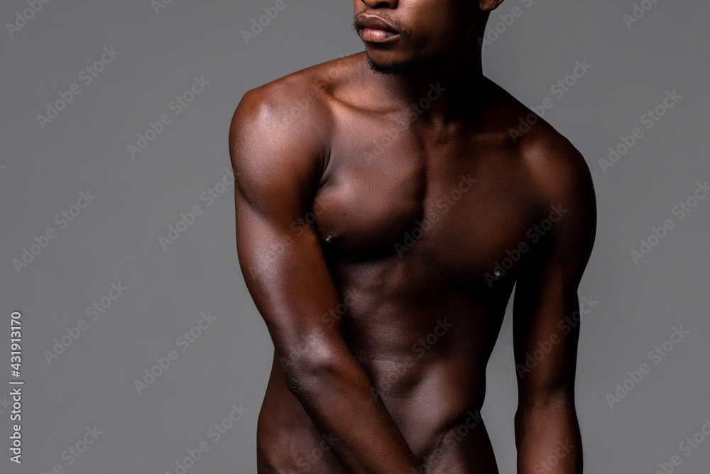 Nude lean young African man body in studio isolated gray background Nude lean young African man body in studio isolated gray background