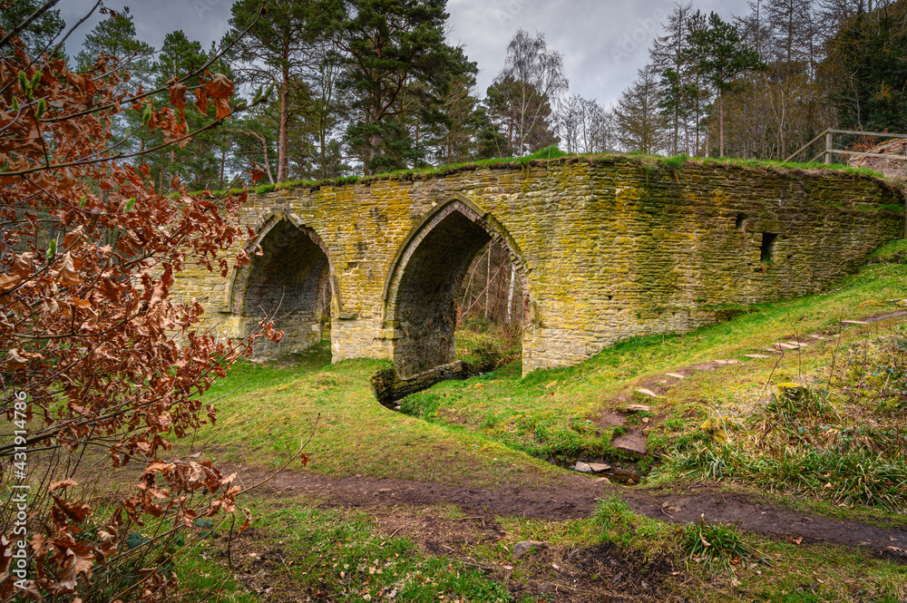 Dukesfield Mill Gothic Arches, the remains of a lead smelting mill which was built in the 18th century, situated in woodland on the banks of Devils Water near Hexham in Northumberland