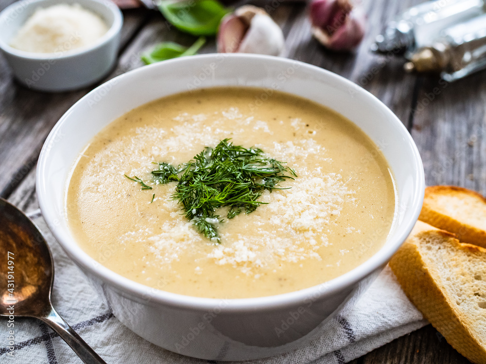 Cream garlic and parmesan soup on wooden table
Cream garlic and parmesan soup on wooden table