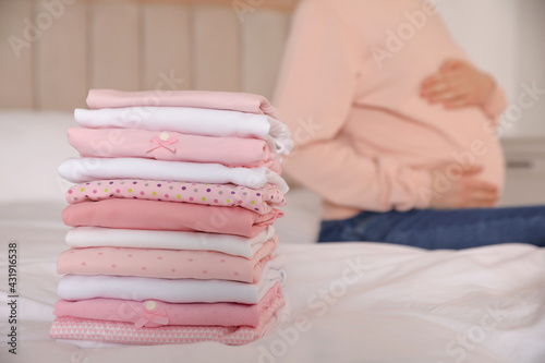 Pregnant woman in bedroom, focus on girl's clothes