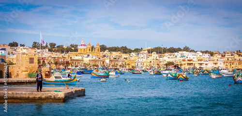 a group of people sitting in a harbor next to a body of water in Malta