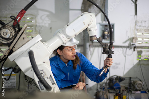 Woman mechanic repairing a robot machine.