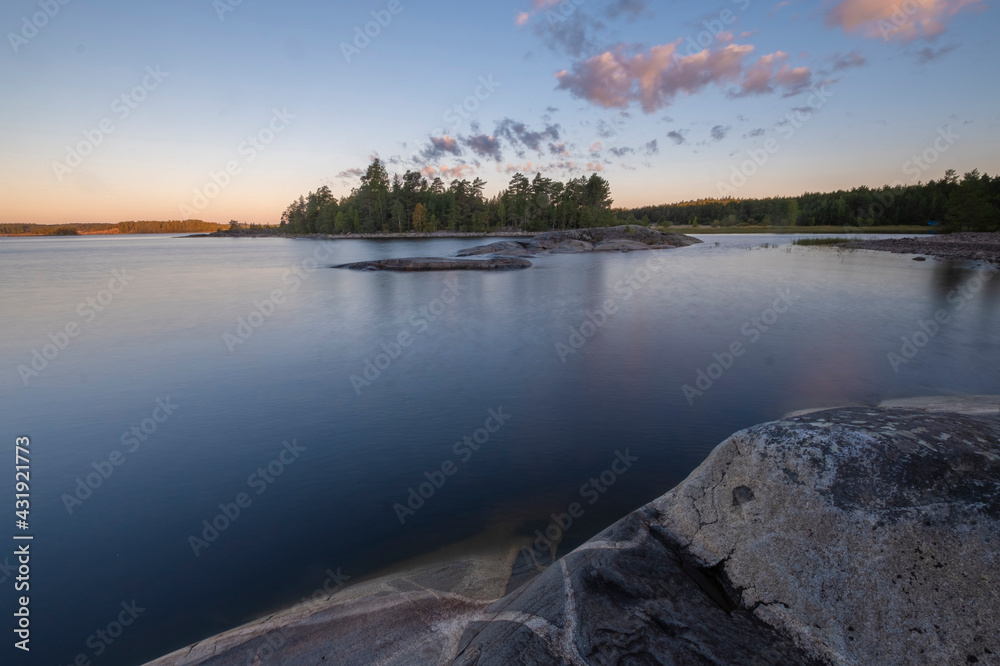 rocky shore of Lake Ladoga, Karelia, Russia with a view of the island on a summer morning. .water on long exposure. rocky shore of Lake Ladoga, Karelia, Russia with a view of the island on a summer morning. .water on long exposure.