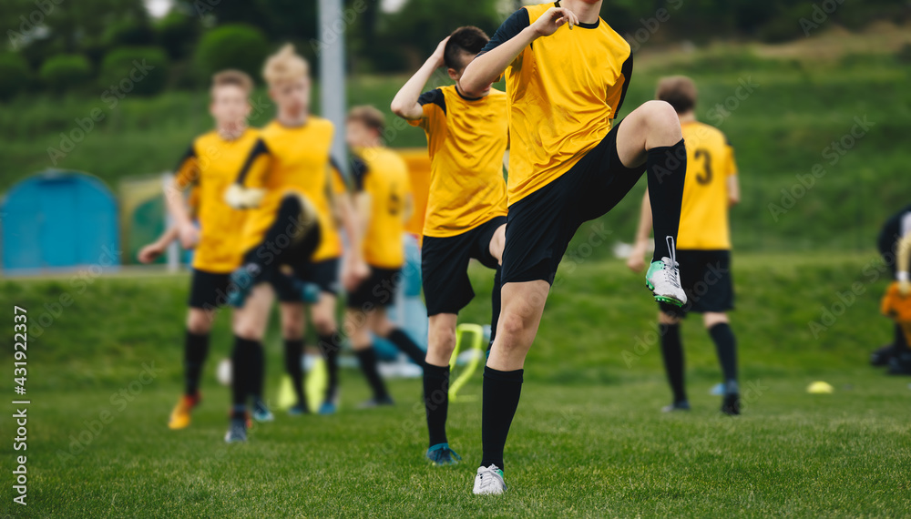 Obraz premium Group of Teenage Soccer Players on Training Session. Boys Stretching on Practice Unit Before the Game. Young Athletes Practicing Together on Grass Pitch